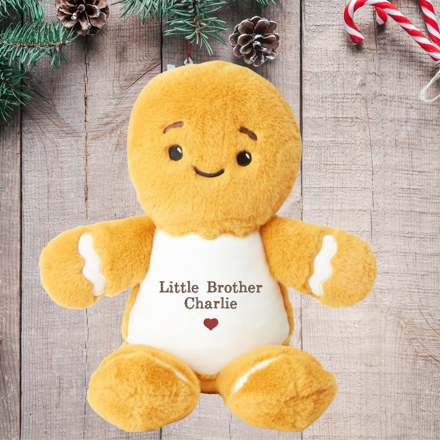 Plush gingerbread toy with 'Little Brother Charlie' text on a wooden surface with Christmas decorations.